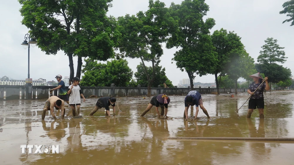 Người dân dọn dẹp vệ sinh sau khi nước rút tại Lào Cai. (Ảnh: Hồng Ninh/TTXVN)