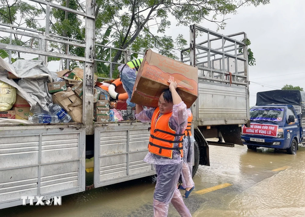 Các đoàn hỗ trợ vận chuyển lương thực và nhu yếu phẩm thiết yếu giúp người dân Hạ Hòa, tỉnh Phú Thọ bị cô lập trong vùng lũ. (Ảnh: Tạ Toàn/TTXVN)