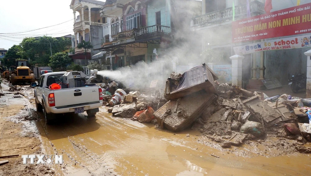 Lực lượng cơ động thực hiện phun khử trùng tại tổ 14, phường Đồng Tâm, thành phố Yên Bái. (Ảnh: TTXVN phát)