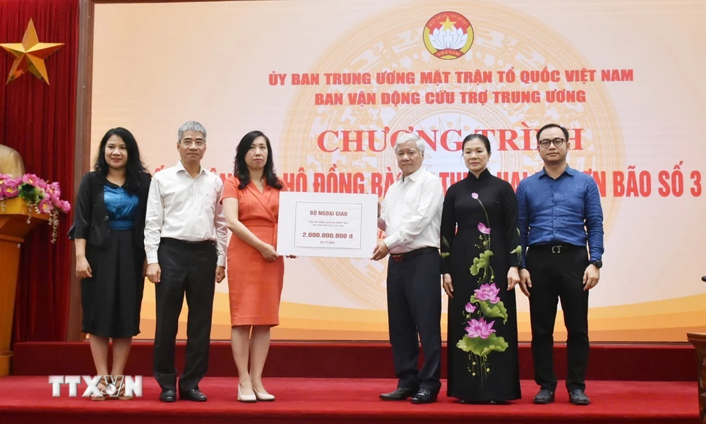 Chủ tịch Ủy ban Trung ương Mặt trận Tổ quốc Việt Nam Đỗ Văn Chiến tiếp nhận bảng tượng trưng số tiền từ Thứ trưởng Bộ Ngoại giao, Chủ nhiệm Ủy ban Nhà nước về người Việt Nam ở nước ngoài Lê Thị Thu Hằng. (Ảnh: TTXVN phát)