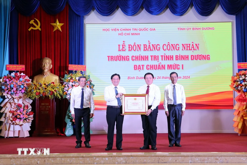 Giáo sư, Tiến sỹ Nguyễn Xuân Thắng, Ủy viên Bộ Chính trị, Giám đốc Học viện Chính trị Quốc gia Hồ Chí Minh, Chủ tịch Hội đồng Lý luận Trung ương trao Bằng chứng nhận cho Trường Chính trị tỉnh Bình Dương. (Ảnh: Dương Chí Tưởng/TTXVN)