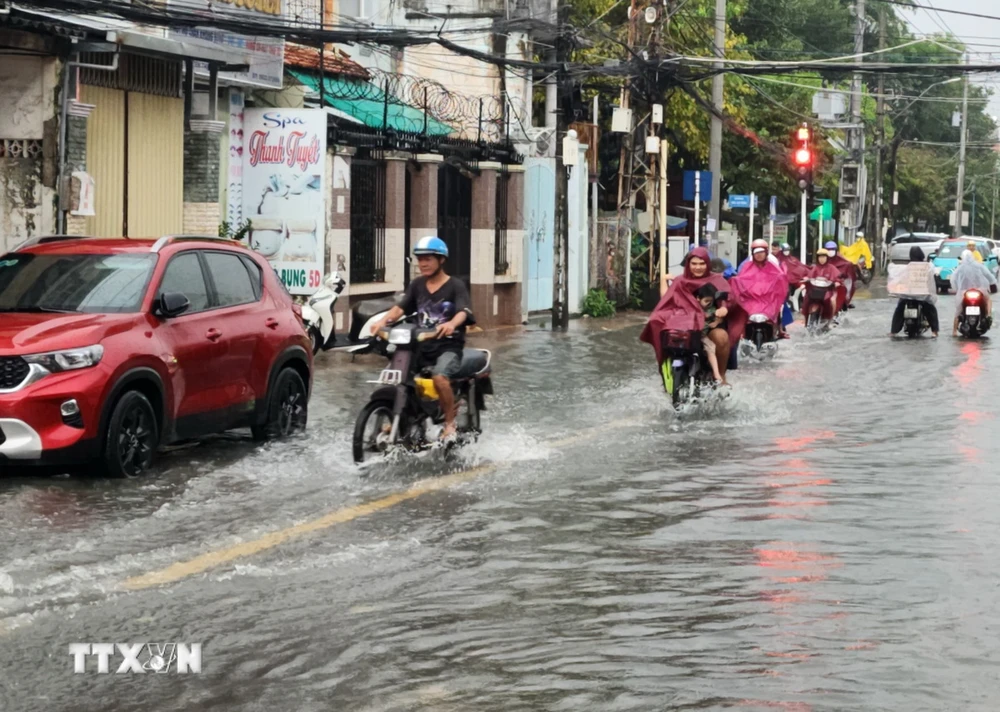 Triều cường vào giờ tan tầm gây nhiều khó khăn cho người dân ở thành phố Vĩnh Long, chiều 16/10. (Ảnh: Phạm Minh Tuấn/TTXVN)