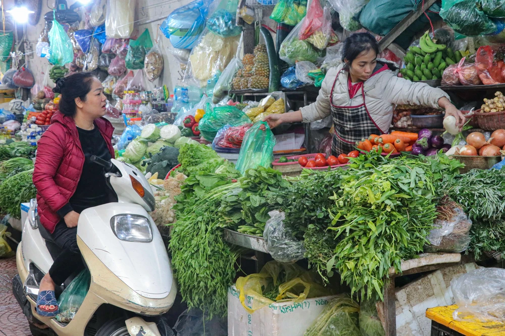 Giá rau xanh tăng cao không chỉ khiến người tiêu dùng 'lao đao' mà các tiểu thương tại chợ cũng gặp khó. (Ảnh: Việt Anh/Vietnam+)