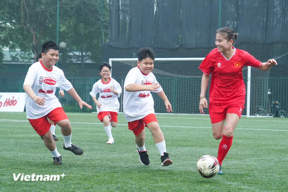 Tuyển thủ Bóng đá Nữ Thái Thị Thảo (áo đỏ) trong trận giao hữu với các bạn nhỏ thuộc Làng trẻ em SOS. (Ảnh: Việt Anh/Vietnam+)