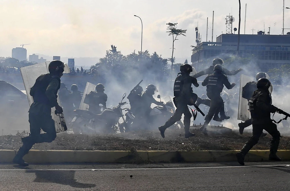 Lực lượng trung thành với Tổng thống Venezuela Nicolas Maduro ngăn các tay súng thuộc nhóm binh sĩ ủng hộ thủ lĩnh đối lập Juan Guaido nổi dậy tại căn cứ quân sự La Carlota ở Caracas ngày 30/4/2019. (Ảnh: AFP/TTXVN)