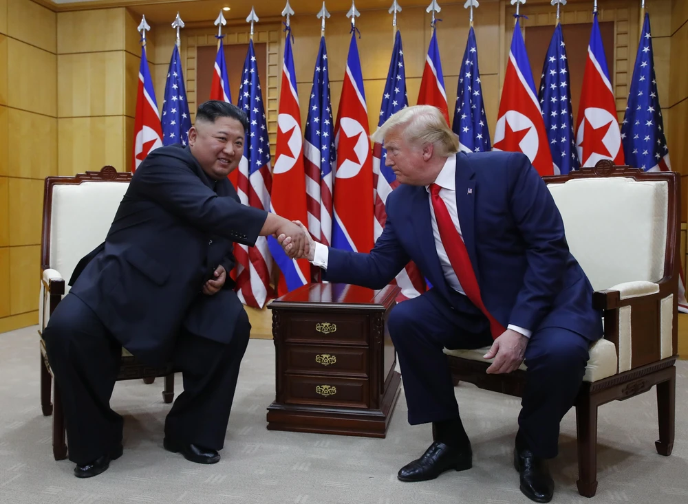 Tổng thống Mỹ Donald Trump (phải) và nhà lãnh đạo Triều Tiên Kim Jong-un trong cuộc gặp ở làng đình chiến Panmunjom tại Khu phi quân sự (DMZ) chiều 30/6/2019. (Ảnh: Yonhap/TTXVN)