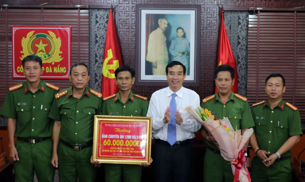 Phó Chủ tịch Ủy ban Nhân dân thành phố Đà Nẵng Lê Trung Chinh trao thưởng cho lực lượng phá án. (Ảnh: Nguyễn Sơn/TTXVN)