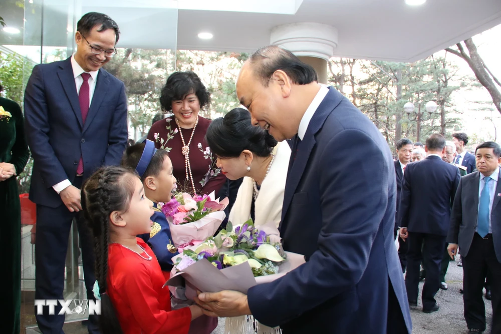 Các em thiếu nhi tặng hoa chào mừng Thủ tướng và Phu nhân tới thăm Đại sứ quán. (Ảnh: Hữu Tuyên/TTXVN)