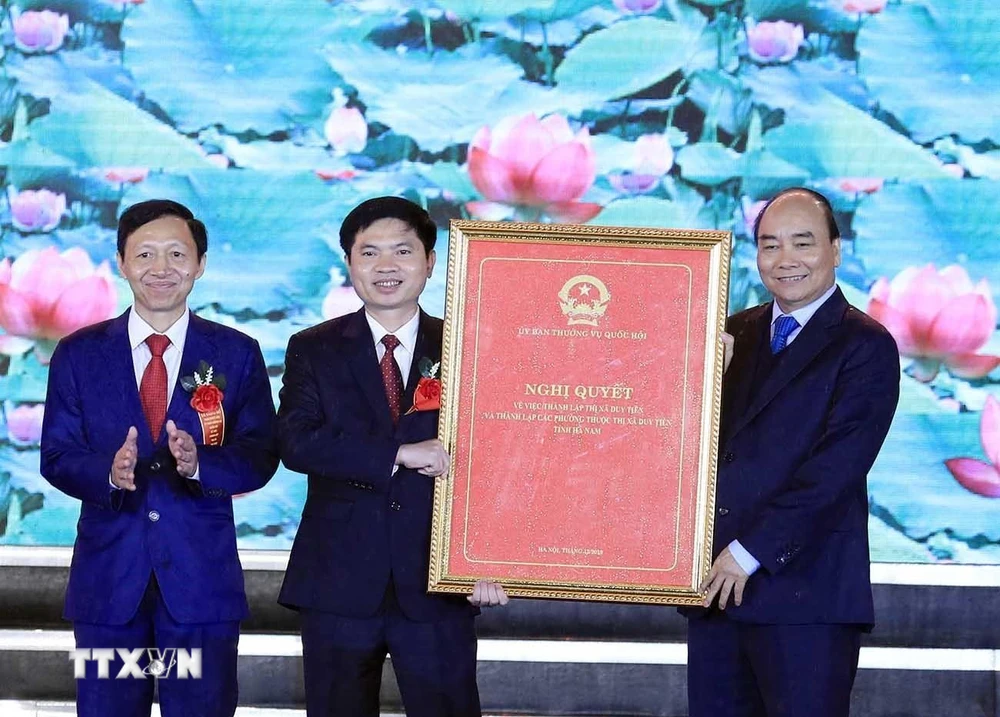 Thủ tướng Nguyễn Xuân Phúc trao Nghị quyết của Ủy ban Thường vụ Quốc hội về thành lập thị xã Duy Tiên, Hà Nam. (Ảnh: Thống Nhất/TTXVN)