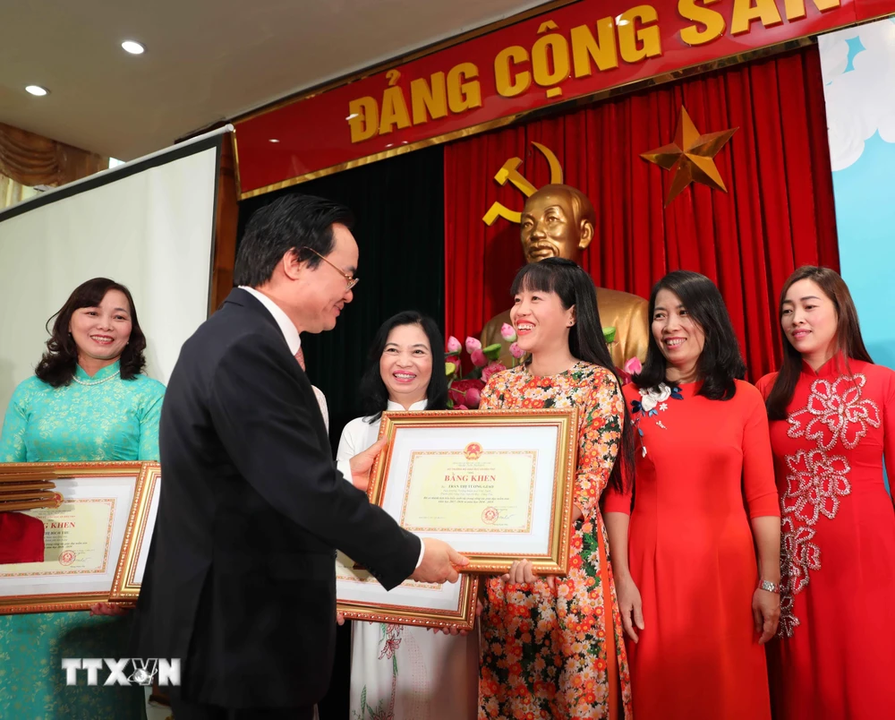 Bộ trưởng Phùng Xuân Nhạ trao bằng khen cho các giáo viên có thành tích xuất sắc trong công tác giáo dục mầm non. (Ảnh: Thanh Tùng/TTXVN)