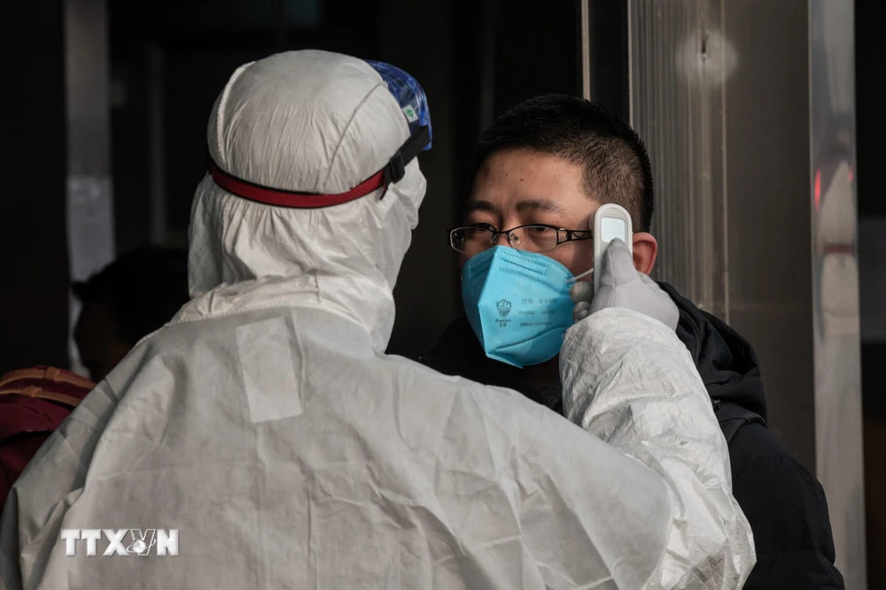 Kiểm tra thân nhiệt một hành khách nhằm ngăn chặn sự lây lan của dịch viêm đường hô hấp cấp do virus corona chủng mới (2019-nCoV) tại nhà ga đường sắt ở Bắc Kinh, Trung Quốc ngày 27/1/2020. (Ảnh: TH/TTXVN)