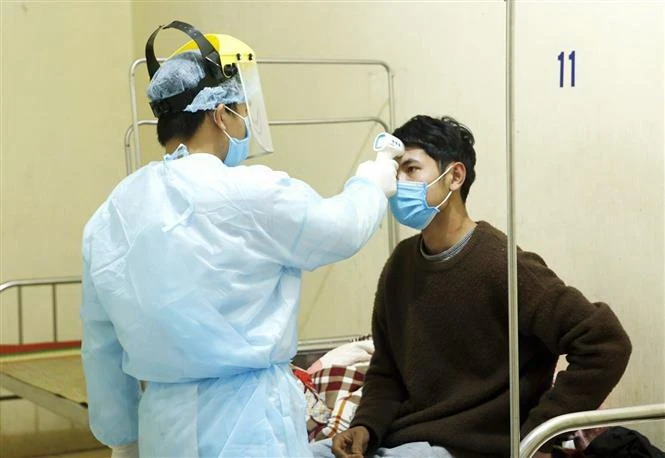 Nhân viên y tế kiểm tra thân nhiệt cho các ca bệnh đang được cách ly theo dõi nCoV tại Trung tâm Y tế Bình Xuyên. (Ảnh: Dương Ngọc/TTXVN)