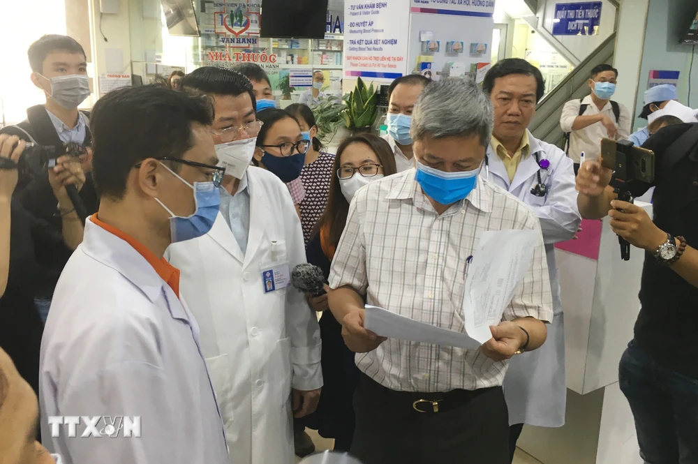 Thứ trưởng Bộ Y tế Nguyễn Trường Sơn kiểm tra quy trình thực hiện điều tra dịch tễ người bệnh tại Bệnh viện đa khoa Vạn Hạnh. (Ảnh: Đinh Hằng/TTXVN)
