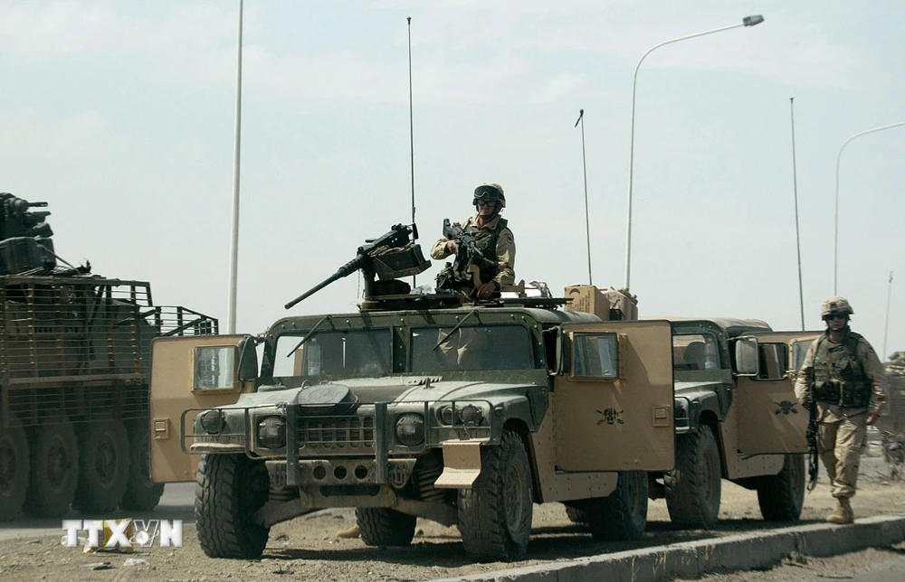 Binh sỹ Mỹ gác trên tuyến đường cao tốc tới khu vực al-Taji, cách Baghdad, Iraq khoảng 20km về phía Bắc, nơi 5 binh sỹ Mỹ thiệt mạng và 6 người bị thương do các vụ tấn công của phiến quân. (Ảnh: AFP/TTXVN)