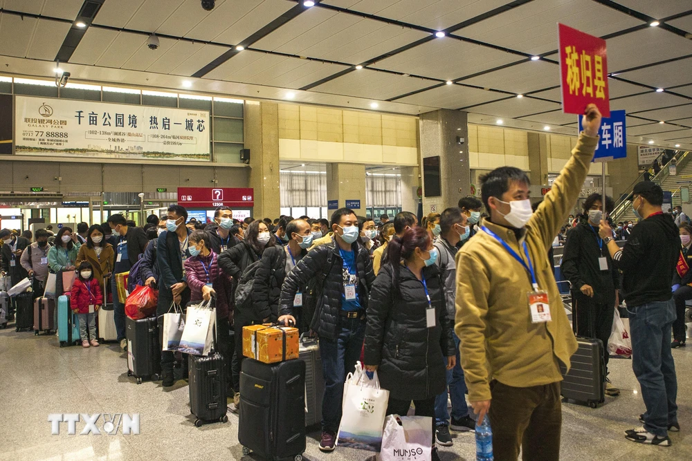 Người dân tại Nghi Xương, tỉnh Hồ Bắc, Trung Quốc chuẩn bị bắt chuyến tàu tới Thâm Quyến tỉnh Quảng Đông để trở lại làm việc, ngày 23/3/2020. (Ảnh: AFP/TTXVN)