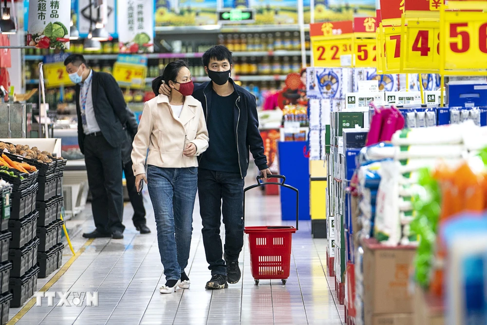 Người dân đeo khẩu trang để phòng tránh lây nhiễm COVID-19 tại siêu thị ở Vũ Hán, tỉnh Hồ Bắc, Trung Quốc, ngày 24/3/2020. (Ảnh: THX/TTXVN)