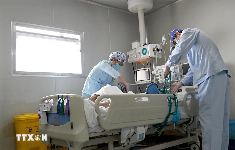 Nhân viên y tế điều trị cho bệnh nhân COVID-19 tại bệnh viện ở Trịnh Châu, tỉnh Hà Nam, Trung Quốc. (Ảnh: THX/ TTXVN)