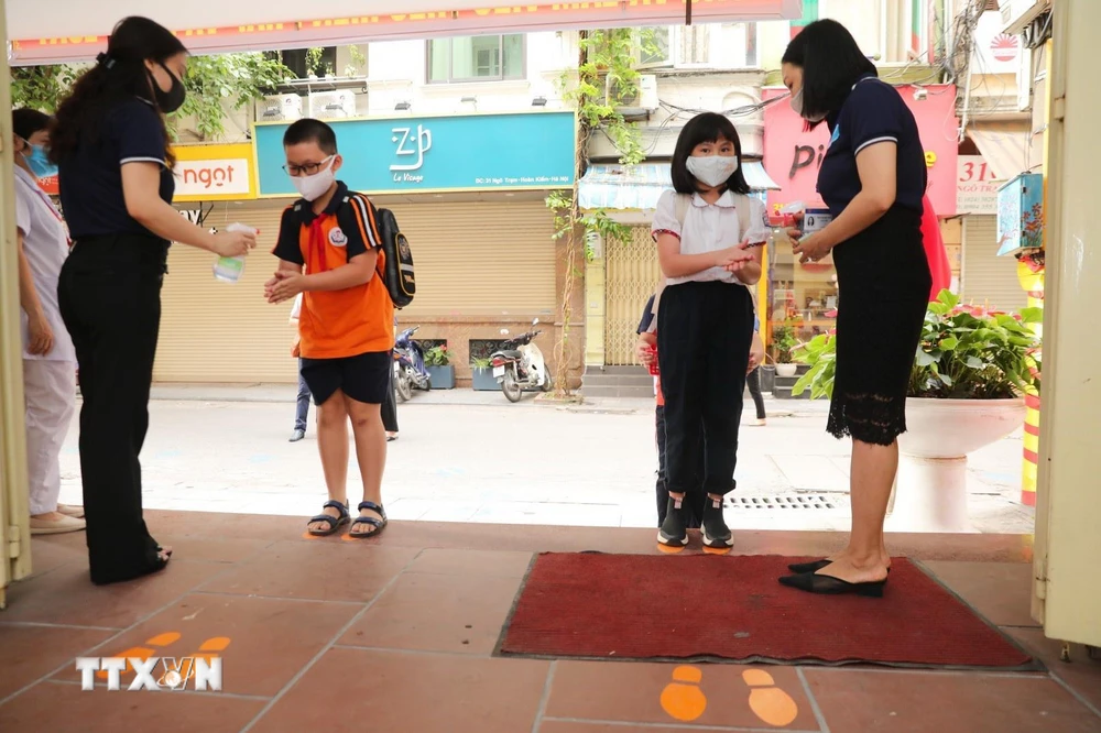 Học sinh trường Tiểu học Thăng Long được rửa tay sát khuẩn trước khi vào trường. (Ảnh: Thành Đạt/TTXVN)