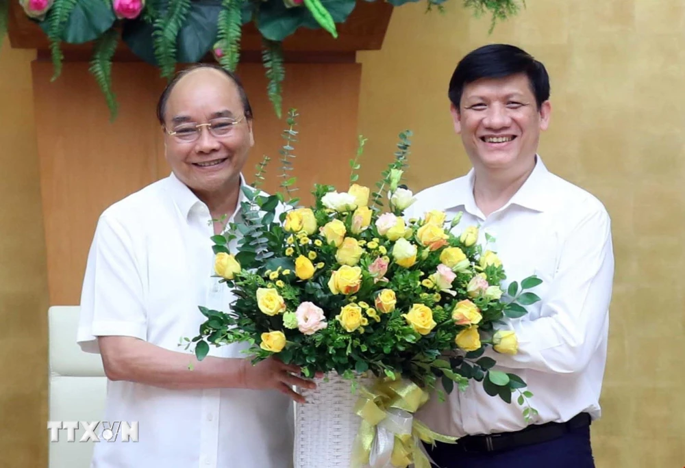 Thủ tướng Nguyễn Xuân Phúc chúc mừng quyền Bộ trưởng Bộ Y tế Nguyễn Thanh Long tại Trụ sở Chính phủ hôm 10/7. (Ảnh: Thống Nhất/TTXVN)