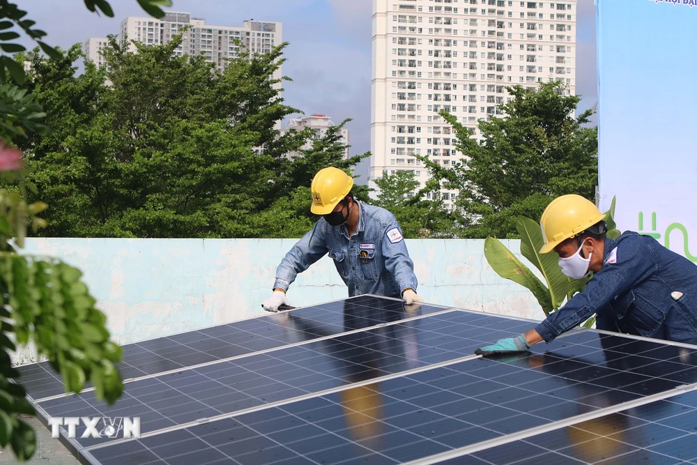Công nhân Tổng công ty Điện lực Thành phố Hồ Chí Minh lắp đặt điện năng lượng mặt trời tại công trình Nhà thiếu nhi Quận 4. 9Ảnh: Thanh Vũ/TTXVN)