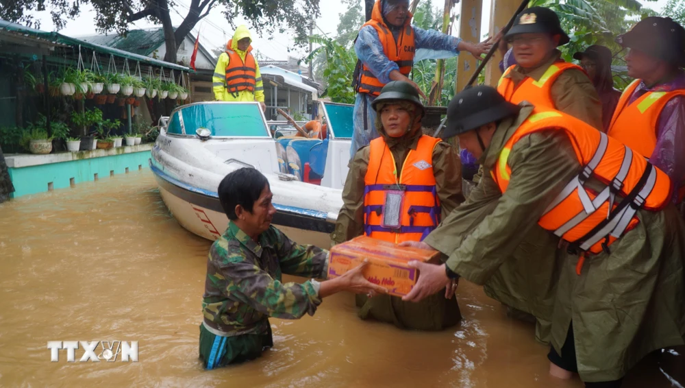 Lực lượng công an tỉnh Thừa Thiên-Huế trao tặng mì tôm cho các gia đình vùng trũng. (Ảnh: TTXVN phát)