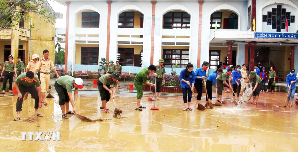 Các đội hình xung kích, tình nguyện của Tuổi trẻ Quảng Bình hăng hái giúp các trường học dọn vệ sinh, khắc phục hậu quả mưa lũ. (Ảnh: Võ Dung/TTXVN)