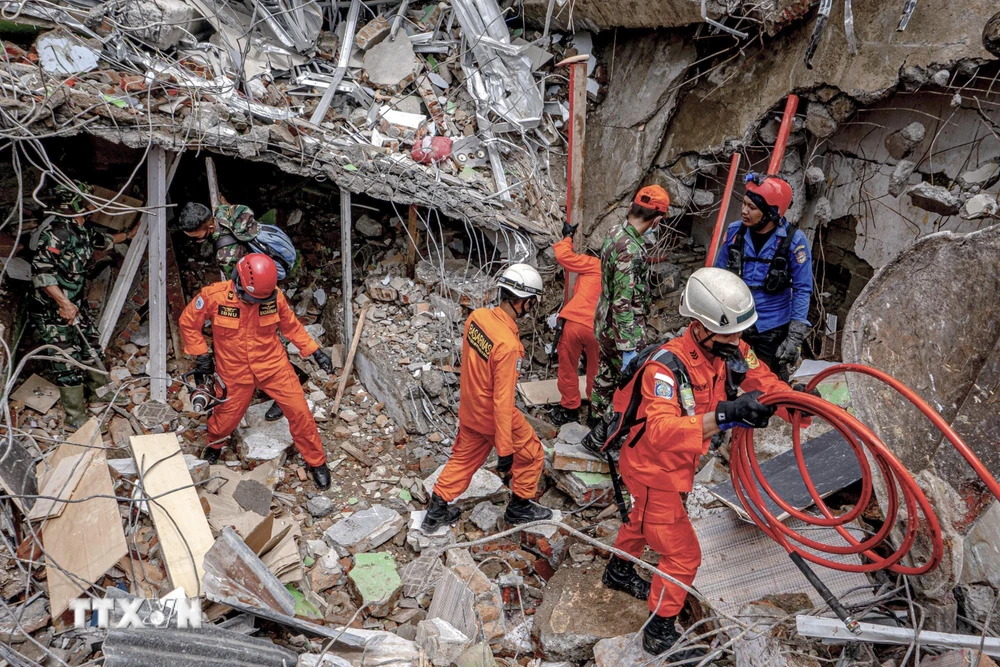 Lực lượng cứu hộ tìm kiếm nạn nhân dưới đống đổ nát của tòa nhà bị sập sau trận động đất ở Mamuju, Tây Sulawesi, Indonesia ngày 16/1/2021. (Ảnh: THX/TTXVN)