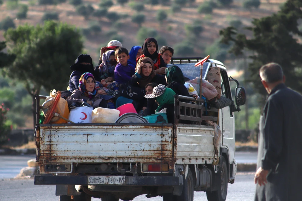 Người dân đi sơ tán để tránh xung đột bạo lực tại tỉnh Idlib, Syria. (Ảnh: AFP/TTXVN)