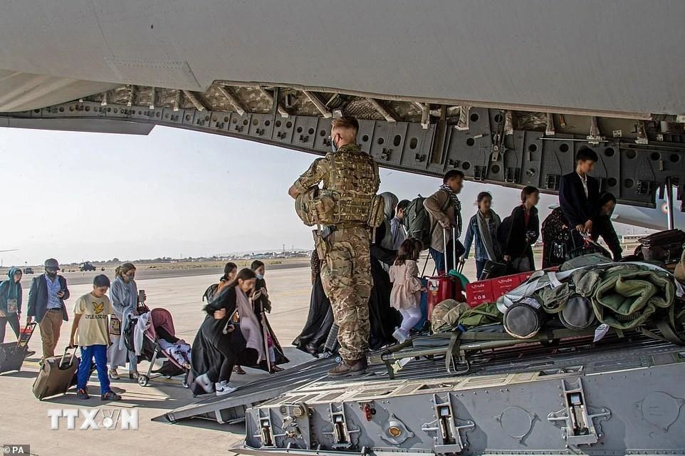 Công dân Anh và người dân Afghanistan mang hai quốc tịch lên máy bay sơ tán khỏi Kabul, ngày 28/8. (Ảnh: PA/TTXVN)