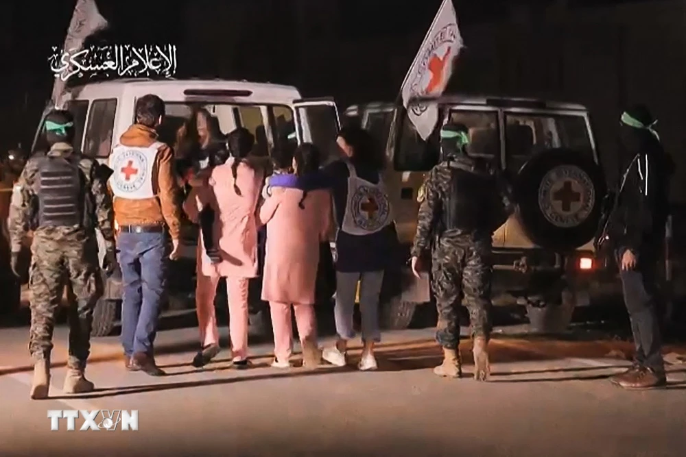 Hình ảnh chụp qua video: Các tay súng Hamas bàn giao nhóm con tin người Israel được trả tự do cho Ủy ban Chữ thập Đỏ Quốc tế, tại Dải Gaza ngày 27/11. (Ảnh: AFP/TTXVN)