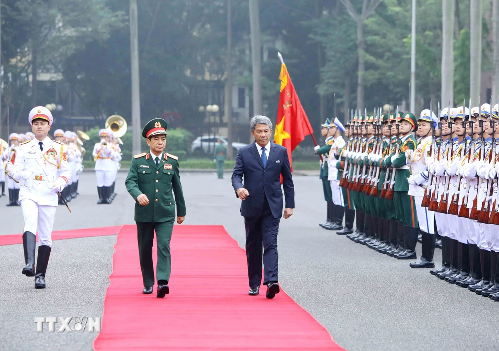 Bộ trưởng Quốc phòng Phan Văn Giang và Bộ trưởng Quốc phòng Malaysia Dato’ Seri Utama Haji Mohamad Bin Haji Hasan duyệt Đội danh dự Quân đội nhân dân Việt Nam. (Ảnh: An Đăng/TTXVN)