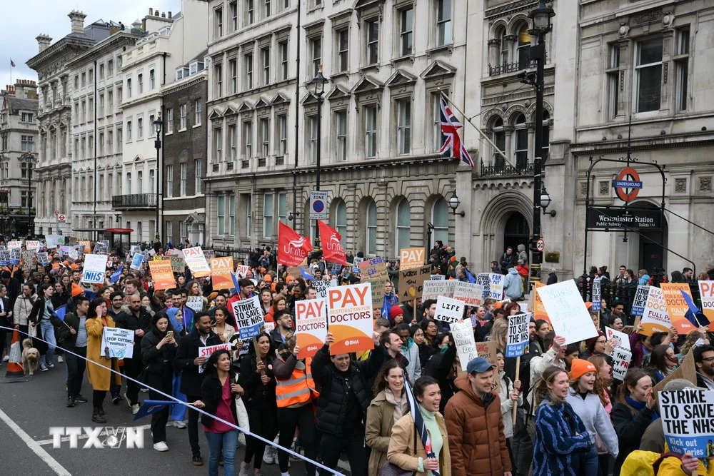 Nhân viên y tế tham gia đình công yêu cầu tăng lương tại London, Anh. (Ảnh: AFP/TTXVN)