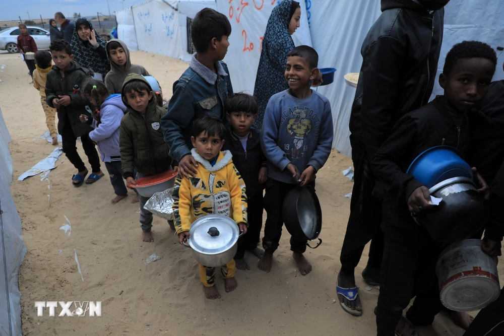 Trẻ em Palestine chờ được phát thực phẩm cứu trợ tại thành phố Rafah, Dải Gaza ngày 18/3. (Ảnh: THX/TTXVN)