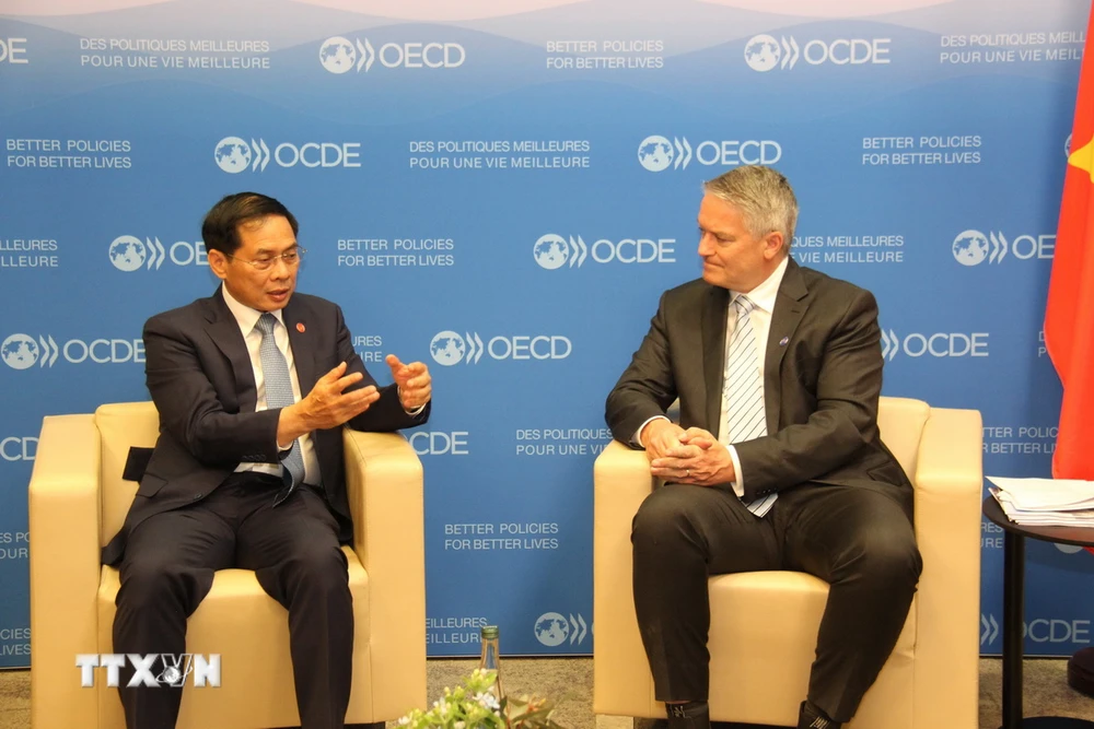 Bộ trưởng Ngoại giao Bùi Thanh Sơn gặp Tổng Thư ký Tổ chức Hợp tác và Phát triển Kinh tế (OECD) Mathias Cormann. (Ảnh: Ngọc Hiệp/TTXVN)