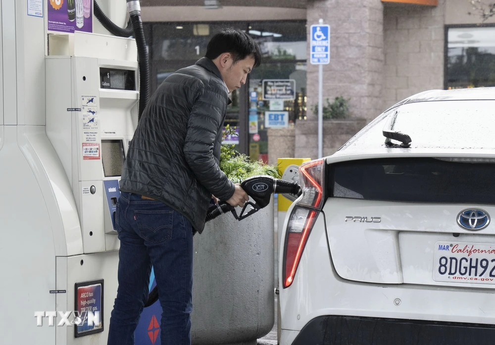 Khách hàng bơm xăng tại một trạm xăng ở Millbrae, bang California, Mỹ. (Ảnh: THX/TTXVN)
