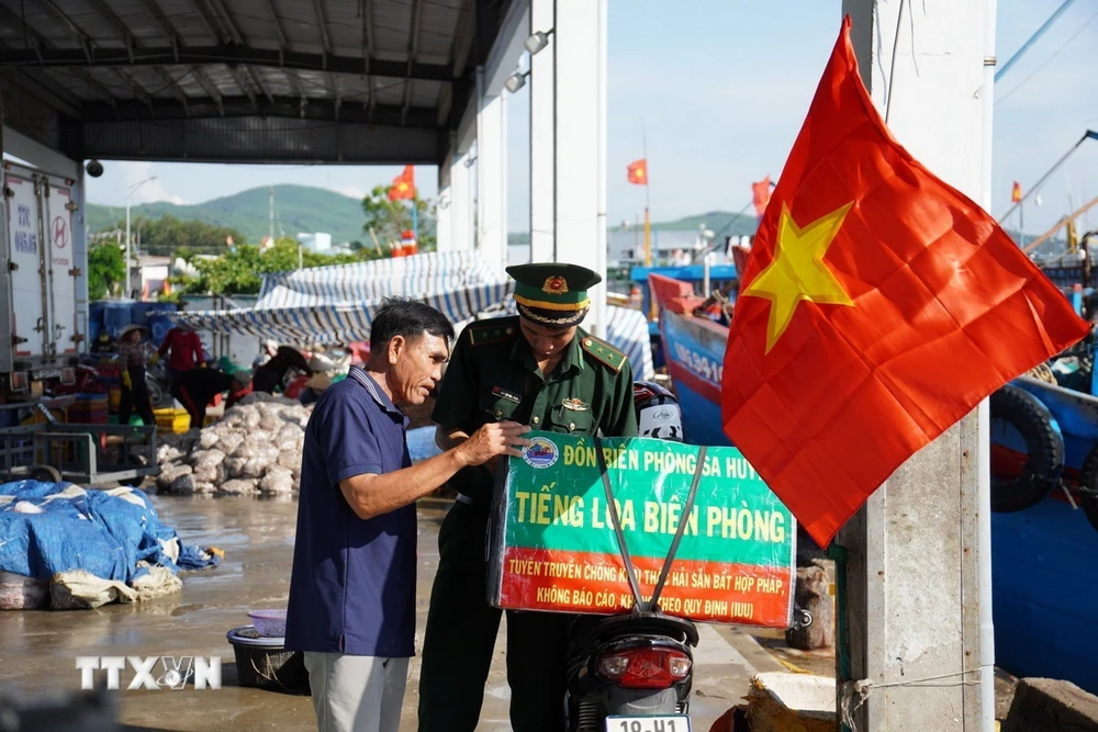 Các chiến sỹ biên phòng cùng với xe gắn máy và chiếc loa kéo mini di chuyển khắp các cảng cá, bến bãi, khu dân cư để tuyên truyền pháp luật. (Ảnh: TTXVN phát)