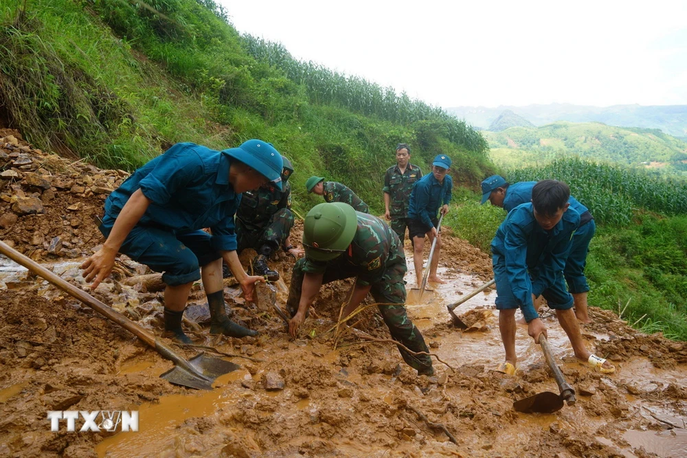 Cán bộ, chiến sỹ Ban Chỉ huy Quân sự huyện Mèo Vạc cùng lực lượng dân quân khơi thông tuyến đường vào thôn Khuổi Roài, xã Tát Ngà bị cô lập do mưa lũ. (Ảnh: Hà Linh/TTXVN phát)