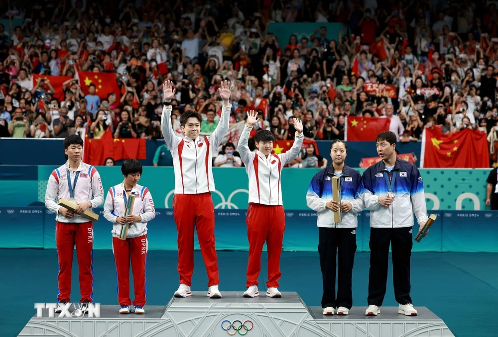 Ri Yong Sik và Kim Kum Yong của Triều Tiên (trái) giành huy chương Bạc nội dung bóng bàn đôi nam nữ tại Olympic Paris 2024, Pháp, ngày 30/7. (Ảnh: THX/TTXVN)