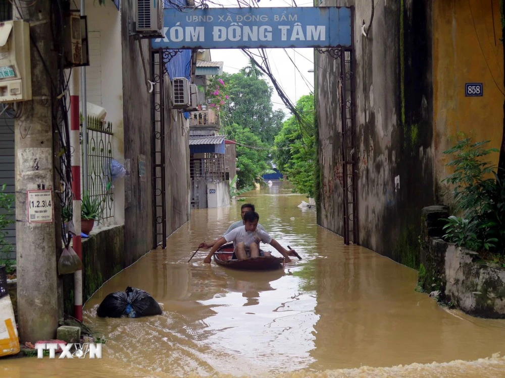 Người dân xã Đồng Bẩm, thành phố Thái Nguyên phải di chuyển bằng thuyền. (Ảnh: Thu Hằng/TTXVN)