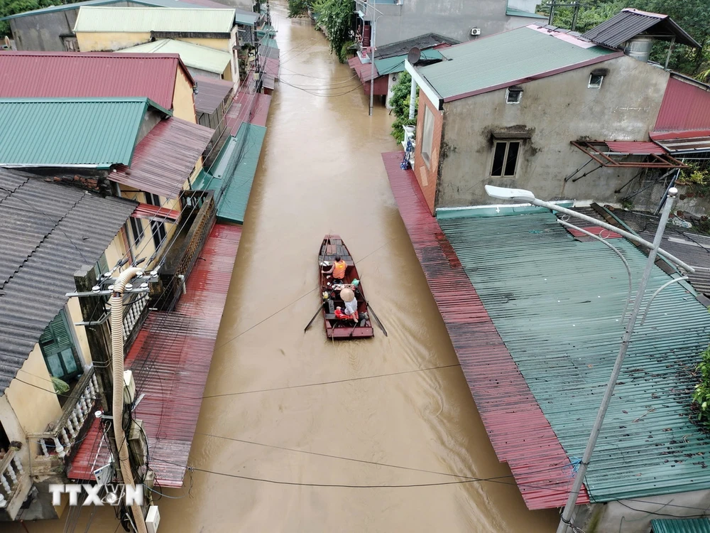 Lực lượng cứu hộ đưa người dân ra khỏi khu vực ngập úng tại đường Thanh Niên, phường Hồng Hà, thành phố Yên Bái. (Ảnh: Tuấn Anh/TTXVN)