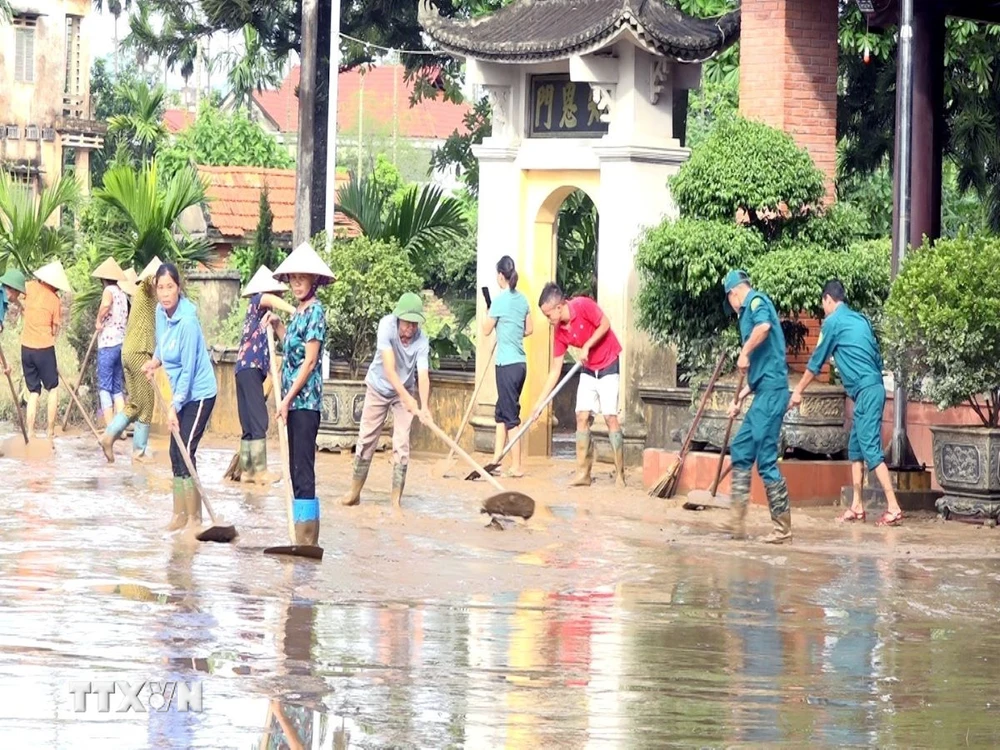 Người dân và các cơ quan chức năng thị trấn Cẩm Khê, huyện Cẩm Khê nỗ lực khắc phục hậu quả sau lũ. (Ảnh: Tạ Toàn/TTXVN)