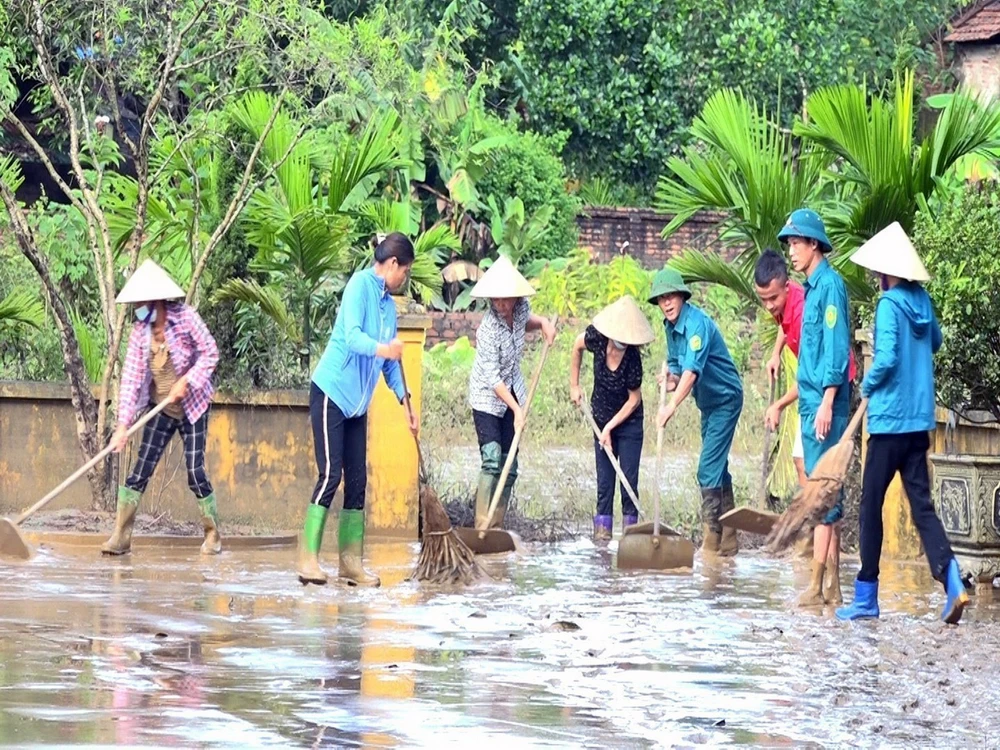 Người dân và các cơ quan chức năng thị trấn Cẩm Khê, huyện Cẩm Khê nỗ lực khắc phục hậu quả sau lũ. (Ảnh: Tạ Toàn/TTXVN)