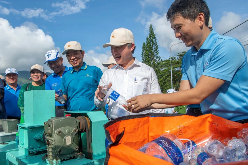 Các vị lãnh đạo và người dân trải nghiệm tái chế rác nhựa tại Ngày hội. 