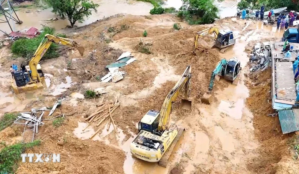 Lực lượng chức năng triển khai xử lý hàng chục ngàn m3 đất đá để sớm thông tuyến Quốc lộ 2. (Ảnh: TTXVN phát.)