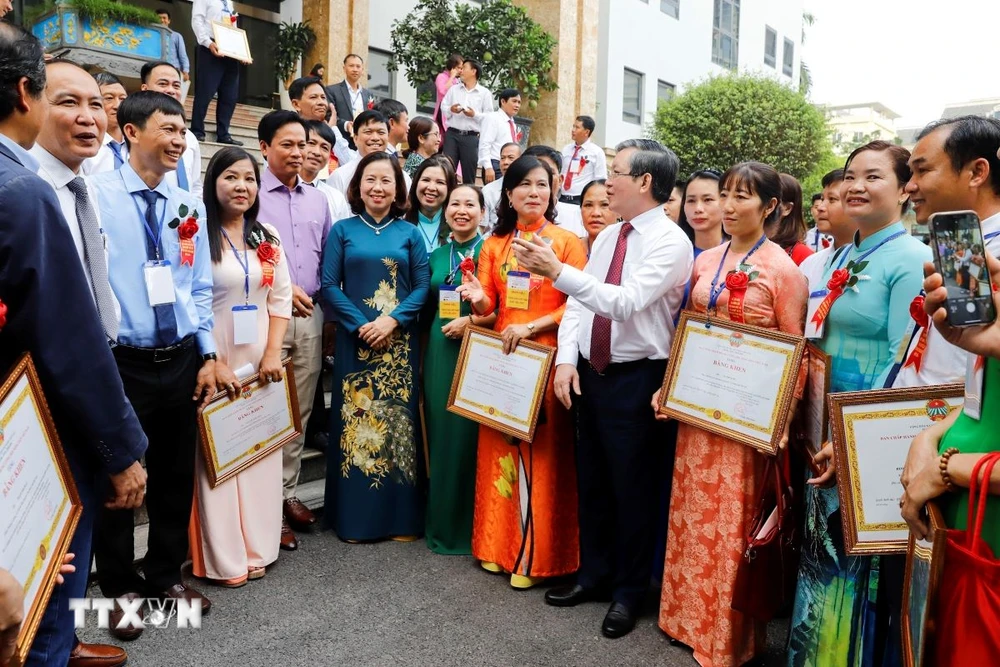 Chủ tịch Trung ương Hội Nông dân Việt Nam Lương Quốc Đoàn nói chuyện với các nông dân Việt Nam xuất sắc. (Ảnh: TTXVN phát)