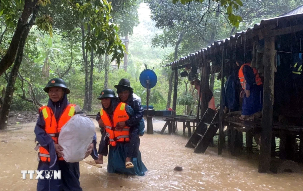 Bộ đội Biên phòng tỉnh Quảng Bình giúp người dân xã Kim Thủy, huyện Lệ Thủy vận chuyển tài sản ra khỏi vùng bị ngập sâu. (Ảnh: TTXVN phát)