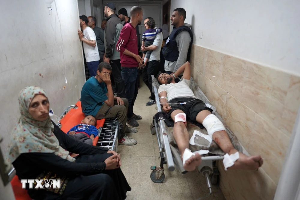 Nạn nhân bị thương sau vụ oanh tạc của Israel ở Deir al-Balah, Dải Gaza. (Ảnh: AFP/TTXVN)