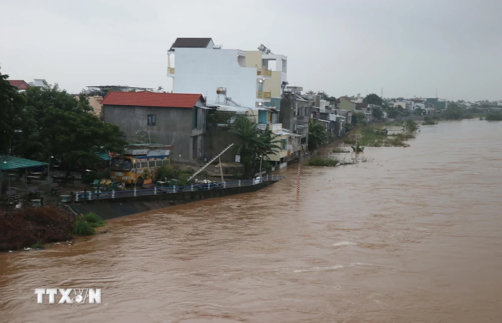 Lũ trên sông Vệ (Quảng Ngãi) lên nhanh áp sát một khu dân cư. (Ảnh: Phạm Cường/TTXVN)