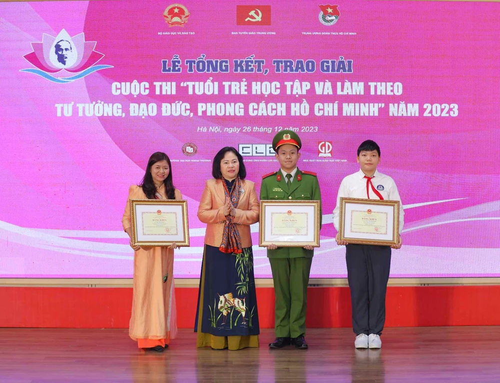 Thứ trưởng Bộ Giáo dục và Đào tạo Ngô Thị Minh trao bằng khen cho các tác giả đạt giải nhất. (Ảnh: Thanh Tùng/TTXVN)