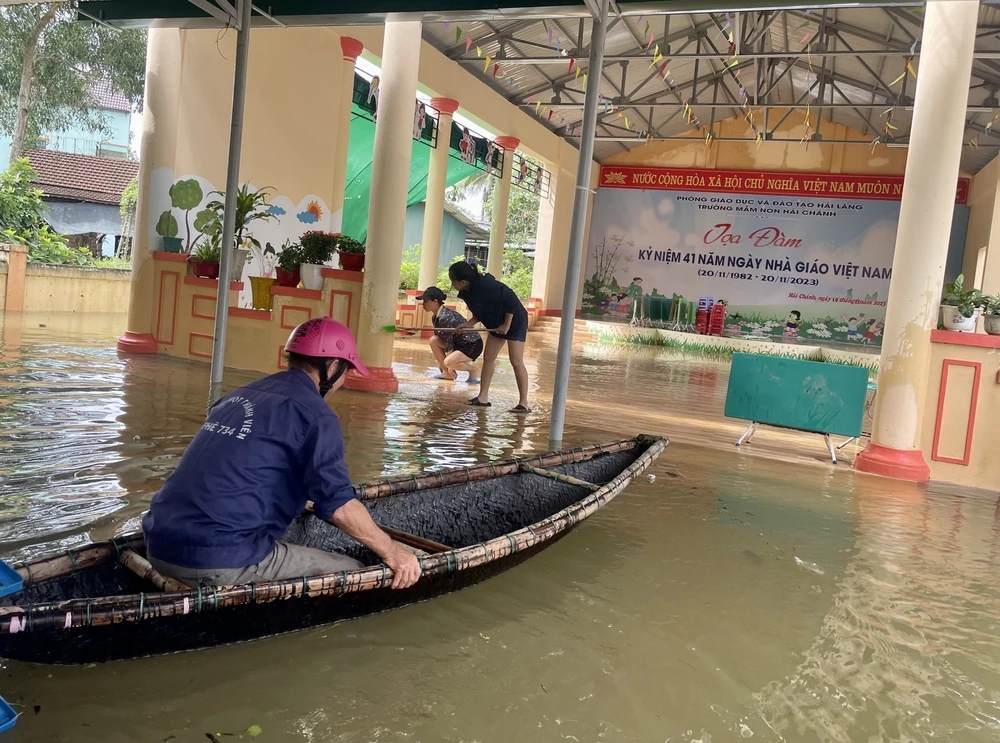 Các cán bộ giáo viên, nhân viên và phụ huynh Trường mầm non xã Hải Chánh, huyện Hải Lăng tích cực dọn vệ sinh trường lớp khi nước bắt đầu rút. (Ảnh: Thanh Thủy/TTXVN)